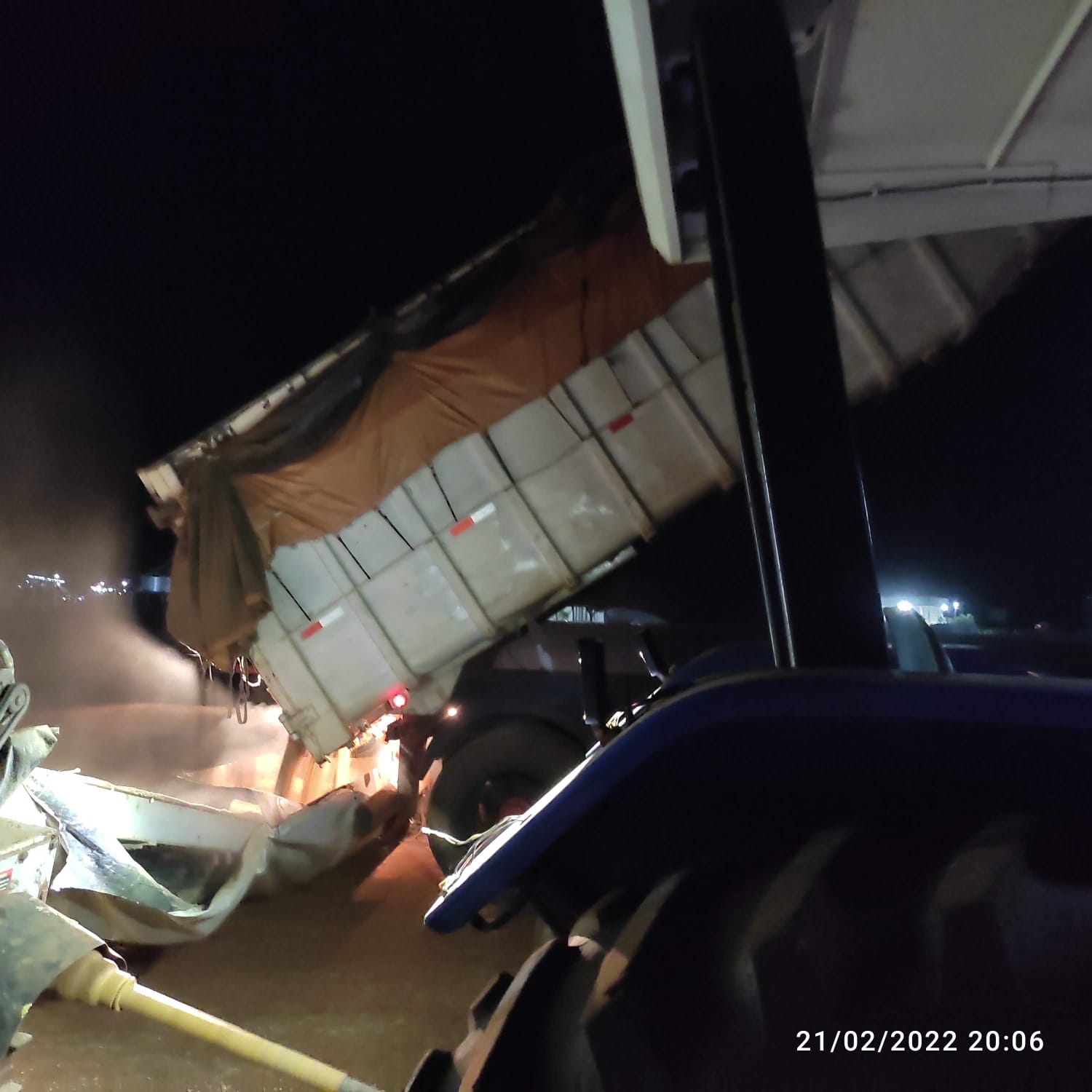 Caminhão basculante durante descarga agrícola noturna